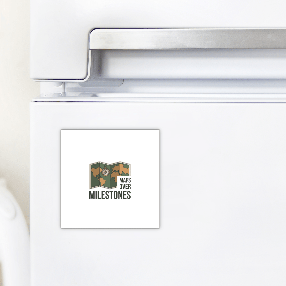 The Maps Over Milestones Travel Magnet by Mirabilia Boutique features a map illustration and bold "MAPS OVER MILESTONES" text—a square, adventure-inspired décor piece perfect for refrigerators or as a gift for explorers.