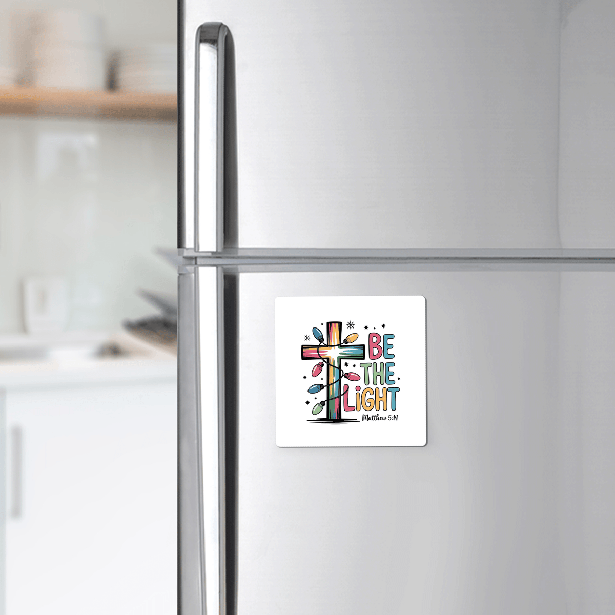 The Be the Light Magnet by Mirabilia Boutique features a vibrant cross and Matthew 5:14—an uplifting Christian fridge decor, ideal as a faith-inspired gift or stocking stuffer for any modern kitchen.