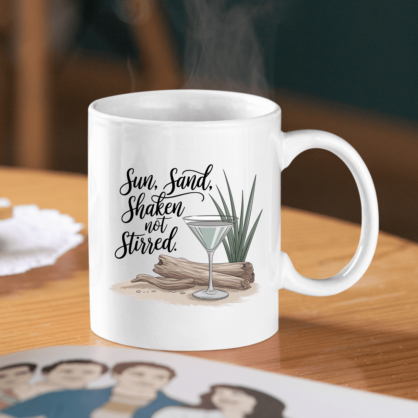 The Sun, Sand, Shaken Not Stirred Mug – Coastal Coffee Vibe by Mirabilia Boutique features a white design with martini glass, driftwood, grass, and the phrase "Sun, Sand, Shaken, not Stirred." Ideal beach house decor.