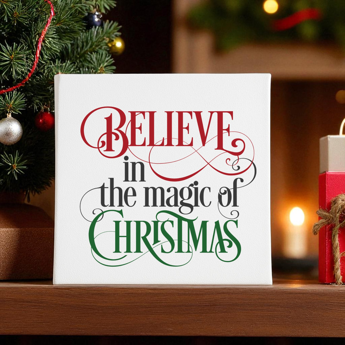 The Mirabilia Boutique “Believe in the Magic of Christmas” wall art features festive red, black, and green script with a Christmas tree and gift boxes—perfect holiday decor for your home.