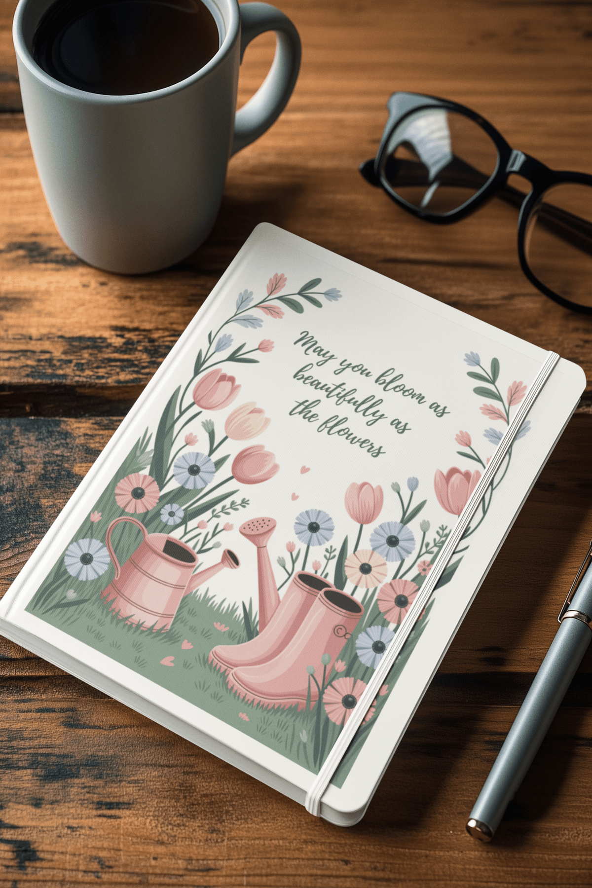 The Bloom Like the Flowers Journal – A5 Spring Floral Notebook by Mirabilia Boutique features floral art, a watering can, boots, and the phrase "May you bloom as beautifully as the flowers"—a perfect gift for garden lovers.
