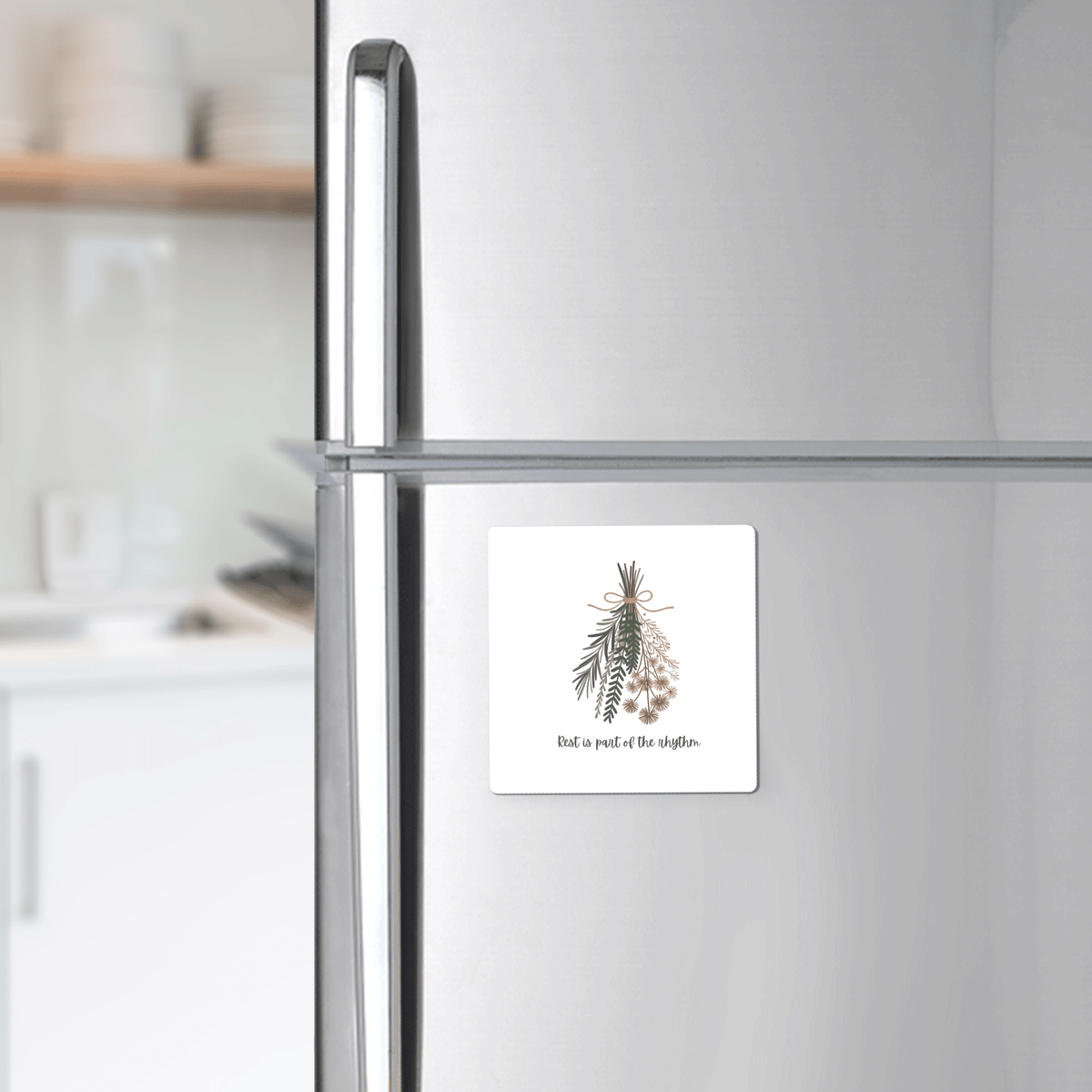 A silver fridge displays Mirabilia Boutique’s Botanical Magnet | Rest Reminder, featuring herbal sprigs and the message "Find a piece of the rhythm"—a perfect minimalist gift for slow living enthusiasts.