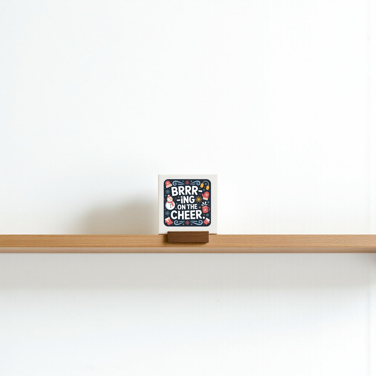 The Mini Brrr-ing on the Cheer Sign by Mirabilia Boutique is a 4x4 holiday shelf decor piece, perfect for tiered trays or as a festive stocking stuffer gift.