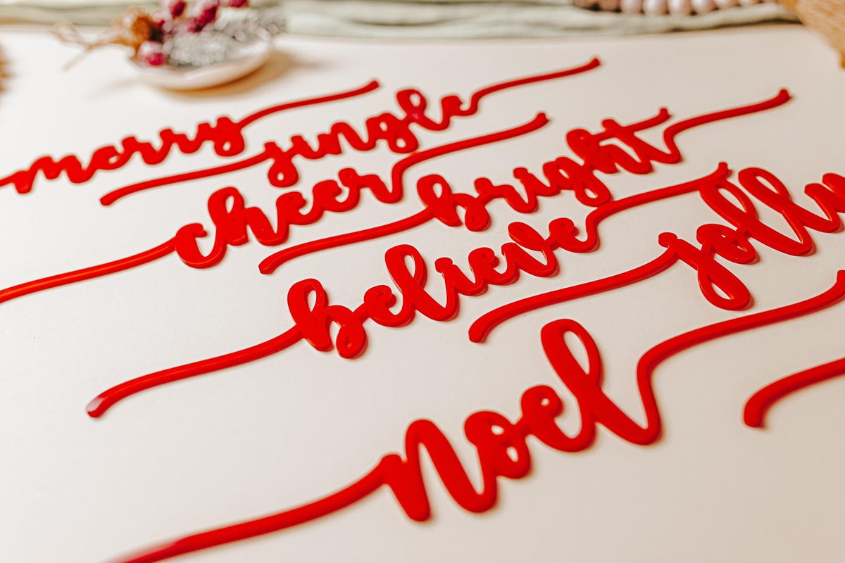 The Mirabilia Boutique Red Acrylic Christmas Plate Words – 8 Piece Holiday Table Decor Set features cursive "merry," "cheer," and "jolly" on a cream plate, adding festive charm to your holiday table.