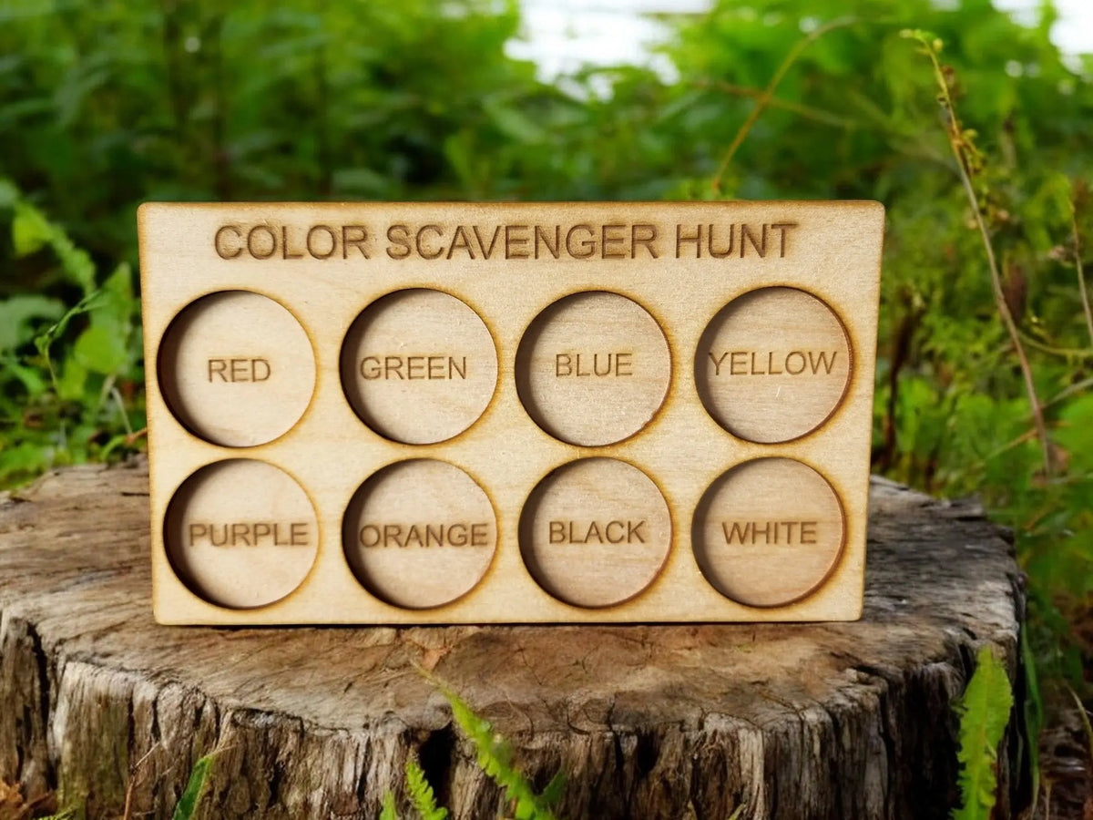 The Mirabilia Boutique Wooden Color Scavenger Hunt Board features eight labeled circles for red, green, blue, yellow, purple, orange, black, and white—a Montessori outdoor toy perfect for nature play and reusable screen-free fun for kids.