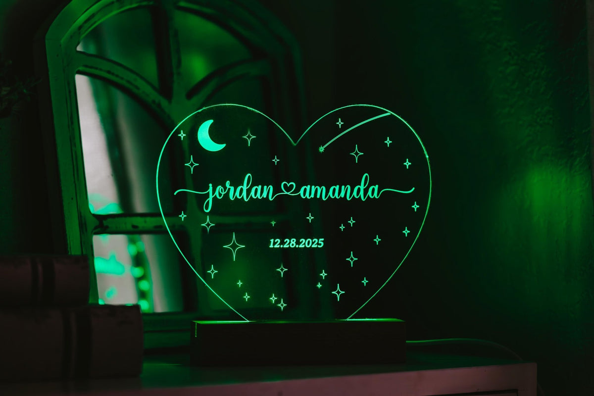 The Mirabilia Boutique Personalized Couples LED Night Light features a custom green heart shape with "jordan," "amanda," a moon, stars, and "12.28.2025"—a unique engraved acrylic sign perfect for wedding gifts or romantic bedroom décor.