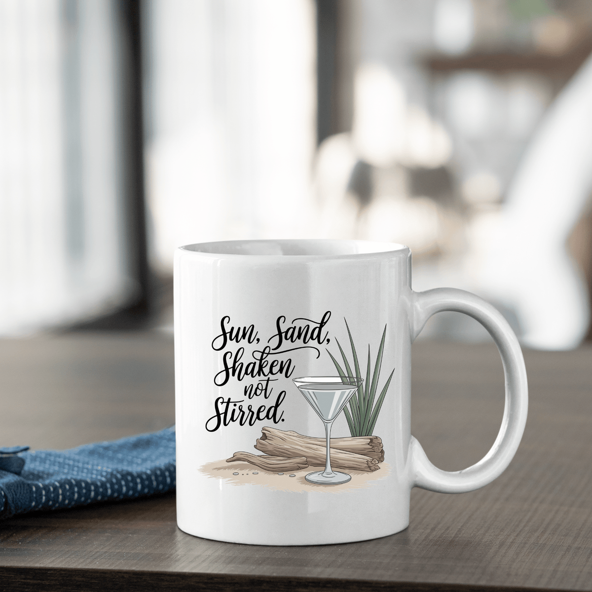 The Sun, Sand, Shaken Not Stirred Mug – Coastal Coffee Vibe by Mirabilia Boutique features a martini glass, driftwood, and grass design with the phrase “Sun, Sand, Shaken not Stirred,” perfect for adding beach house charm.