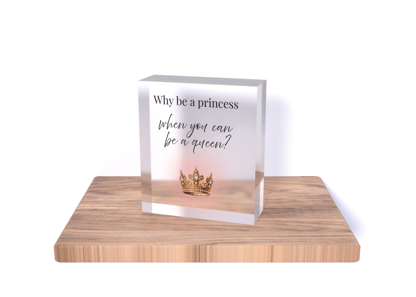 The Mirabilia Boutique "Why Be a Princess When You Can Be a Queen" Acrylic Block Gift for Her features a gold crown design and empowering message, standing on a wooden base—an inspiring decor piece and perfect gift for women.