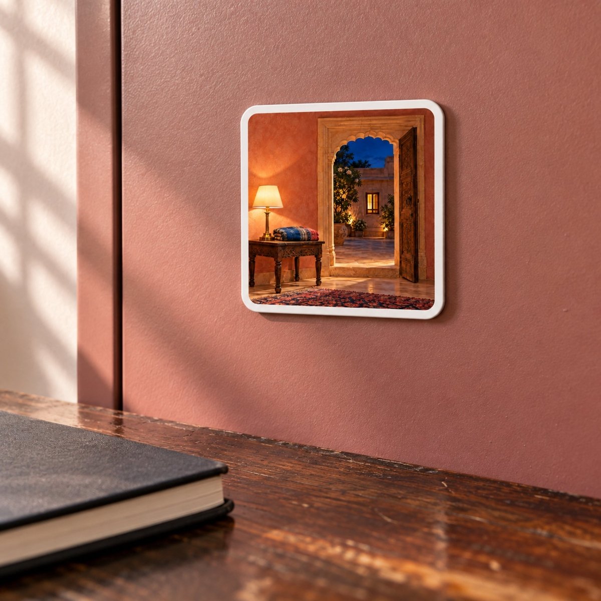 Square The Light Still On Magnet | Sand & Saffron by Mirabilia Boutique on a terracotta wall, depicting a warm indoor scene with a glowing lamp opening onto a courtyard at dusk.