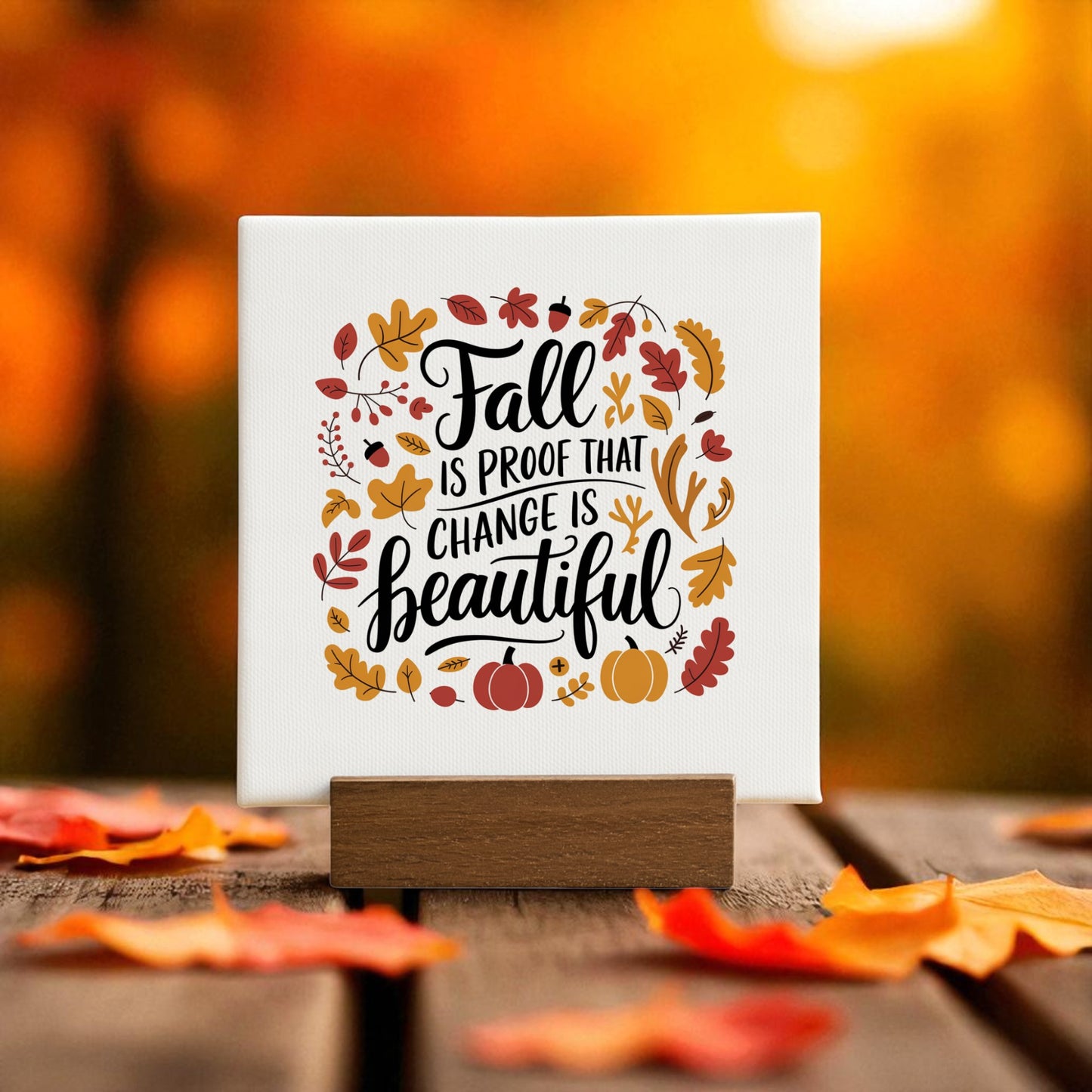 The Fall Is Proof Mini Sign by Mirabilia Boutique features "Fall is proof that change is beautiful" on a small canvas with autumn leaves and pumpkins, making it a perfect inspirational autumn home decor piece.