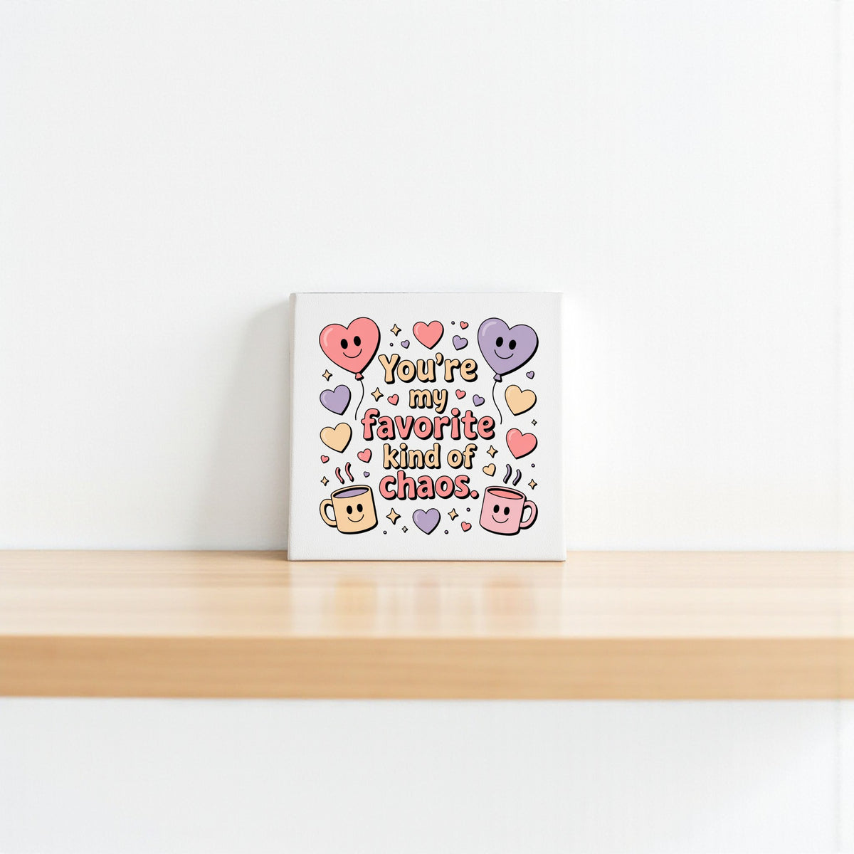 The Mirabilia Boutique "Favorite Kind of Chaos Canvas" features colorful hearts, smiling mugs, and playful text—perfect Valentine’s or Galentine’s gift, or cute decor for a best friend.
