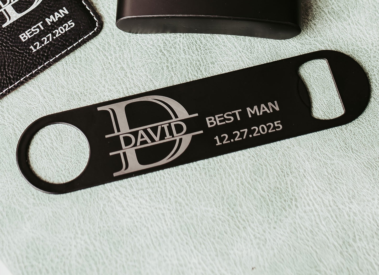 The Personalized Best Man Flask Gift Set by Mirabilia Boutique features a black bottle opener and flask, both engraved with "DAVID," "BEST MAN," and "12.27.2025"—an ideal custom groomsmen present.