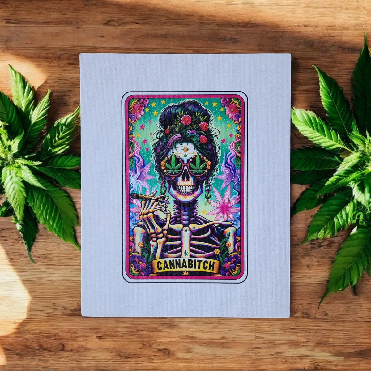 Mirabilia Boutique's Cannabitch Canvas Wall Art is an 8x10 UV printed artwork featuring a bold skeleton stoner queen with sunglasses, cannabis leaves, and psychedelic designs. A fun gift for her, perfect for stoner décor.