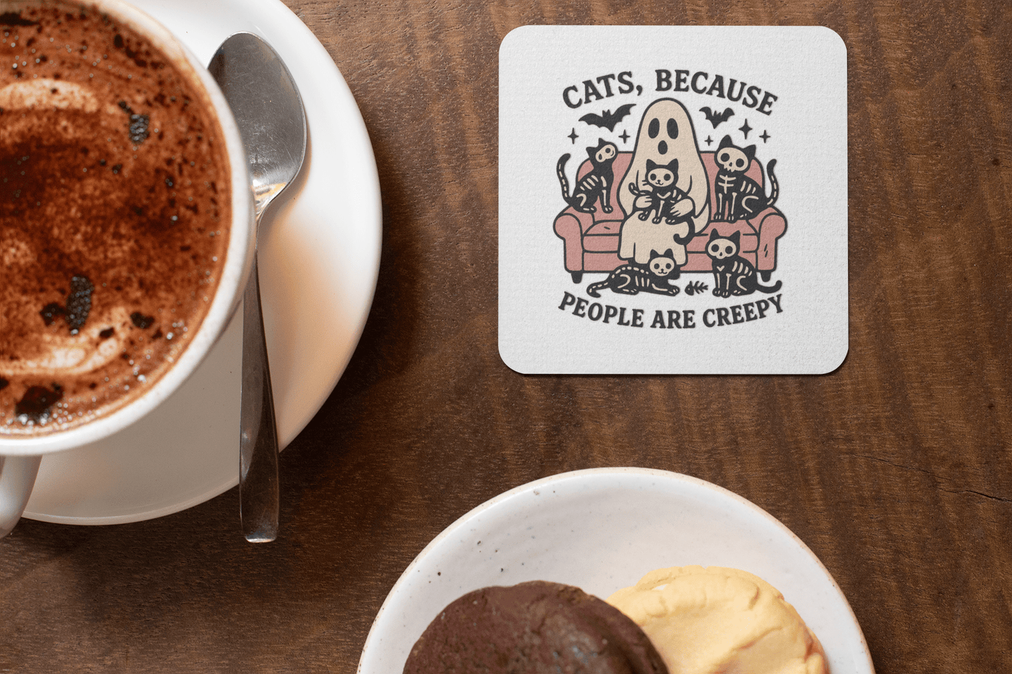 The Mirabilia Boutique "Funny Ghost Cat Coaster | Cats Because People Are Creepy" features a cartoon ghost and cats on a couch—an adorable, spooky gift for cat lovers, perfect for your coffee table beside hot chocolate and cookies.