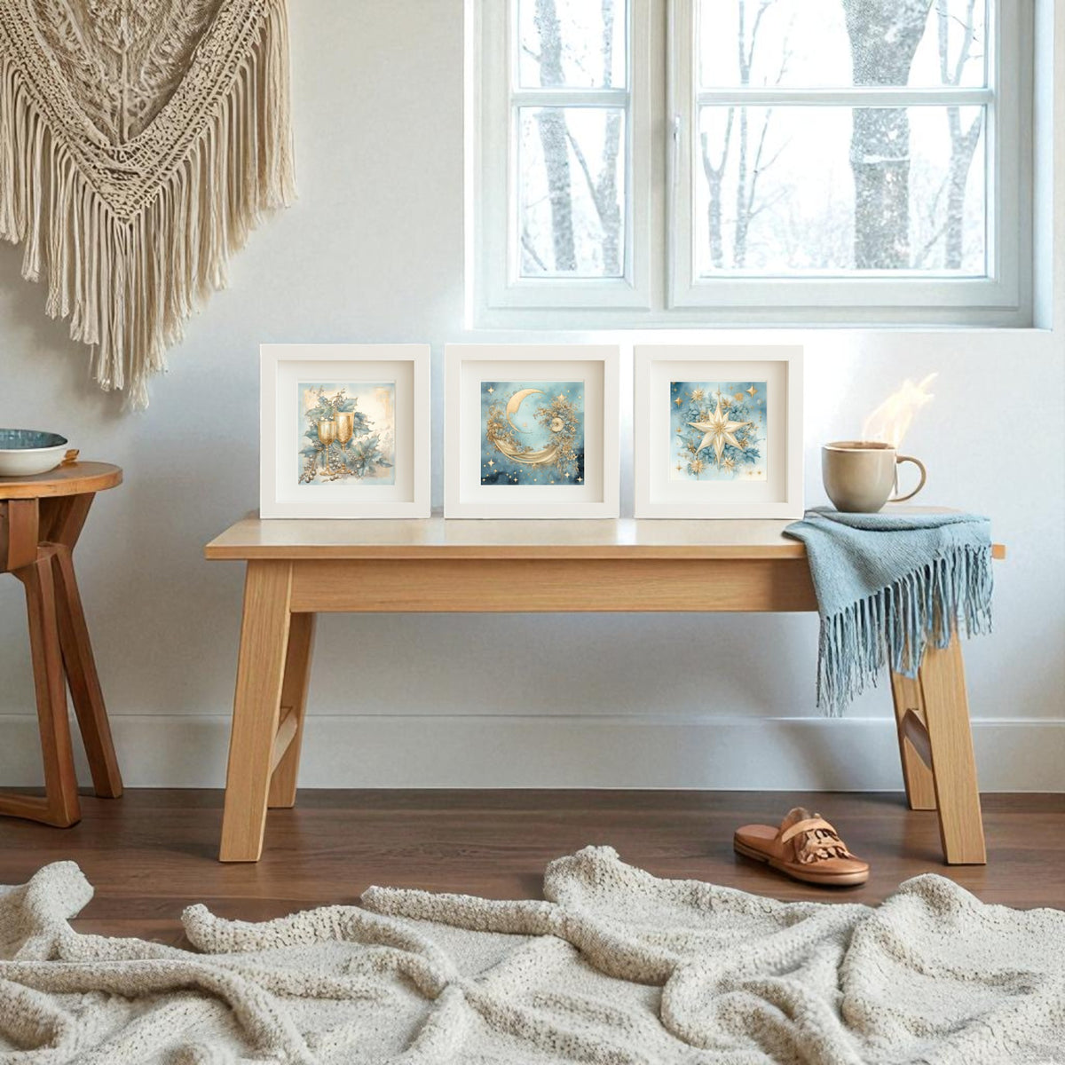 A cozy room features the Mirabilia Boutique Goblet, Moon & Star Holiday Trio—5x5 Celestial Christmas Shadowboxes—on a wooden bench. A steaming mug, blue throw, woven rug, and sandal complete the winter charm by the window with bare trees.