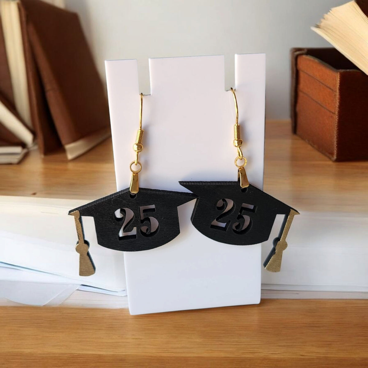Mirabilia Boutique's Graduation Cap Earrings Class of 2025 are black cap-shaped, laser-cut jewelry with gold tassels and "25" detail—an ideal grad gift or party accessory for her.