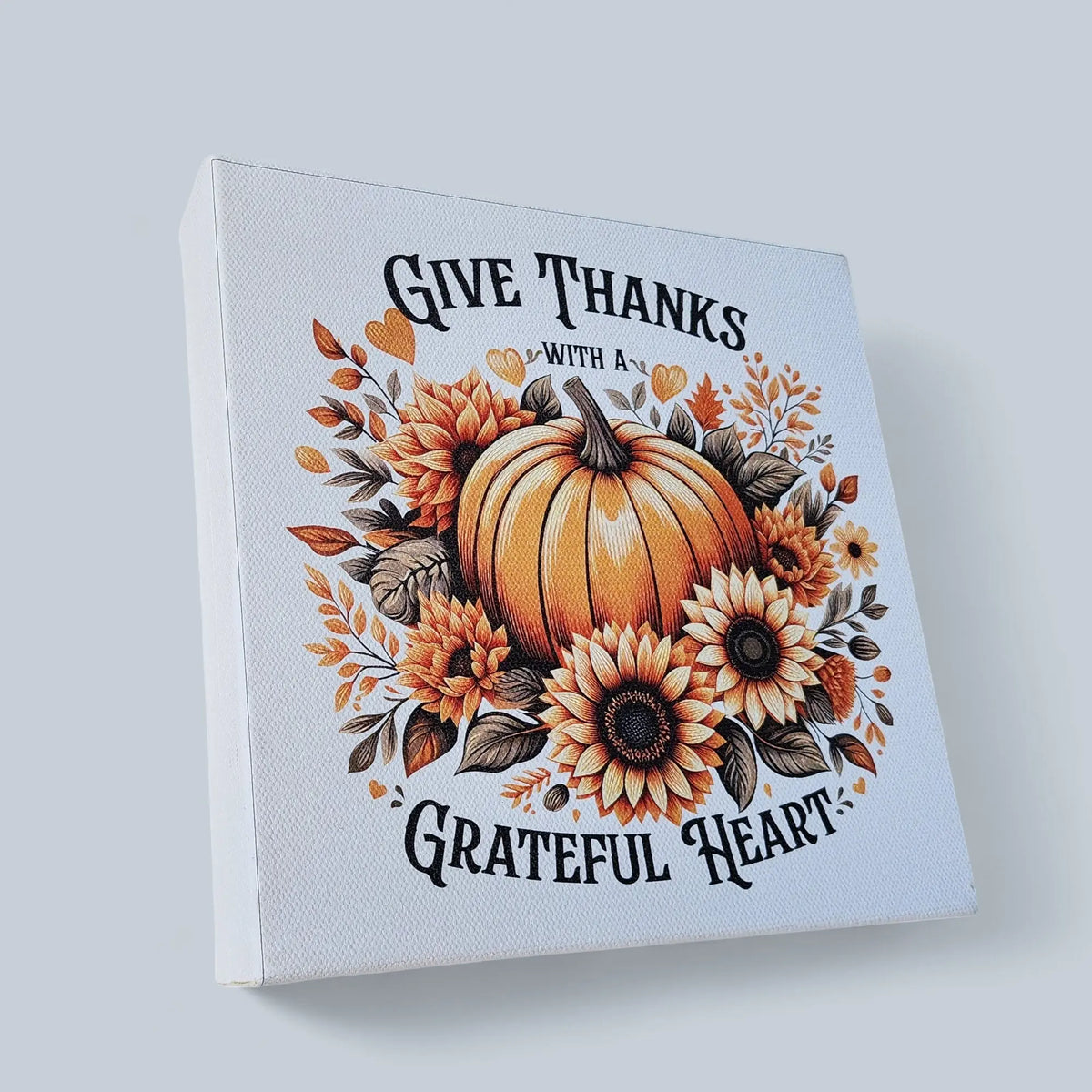 Mirabilia Boutique’s “Give Thanks With a Grateful Heart” 8x8 wood sign features a pumpkin, sunflowers, and autumn leaves—perfect Thanksgiving wall décor for creating warm, inviting fall vibes.