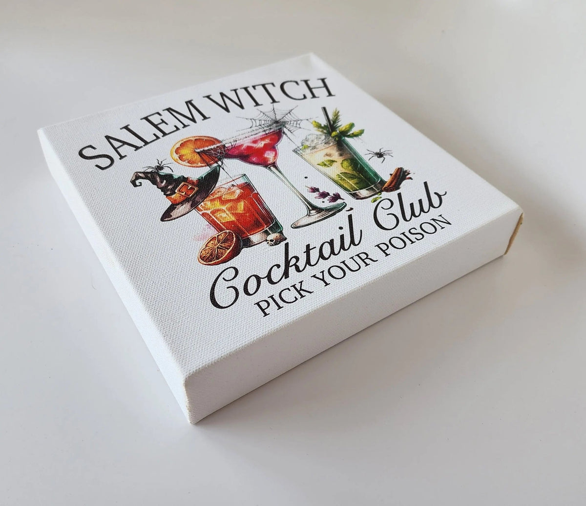 The Mirabilia Boutique Salem Witch Cocktail Club Halloween Canvas (8x8) features three colorful cocktails with spooky accents like a spider and bat—perfect for your Halloween bar cart or witchy gallery wall. Displayed on a white surface.