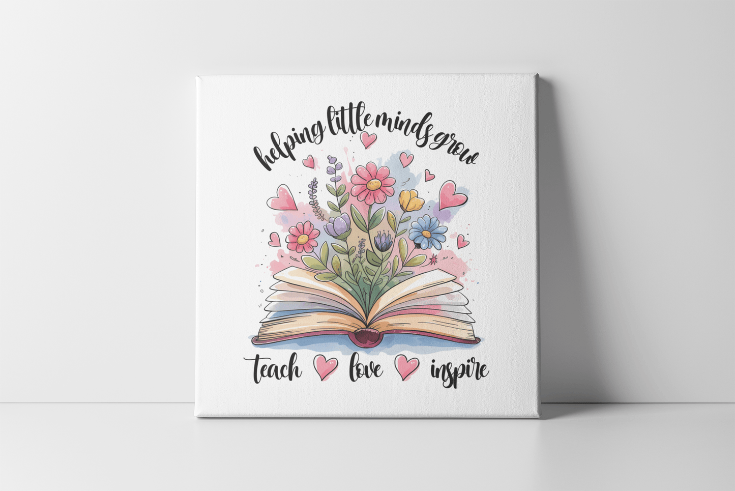 The Mirabilia Boutique Helping Little Minds Grow Mini Canvas with easel features an open book, vibrant hearts and flowers, plus the phrases "helping little minds grow" and "teach, love, inspire"—a perfect decorative teacher gift.