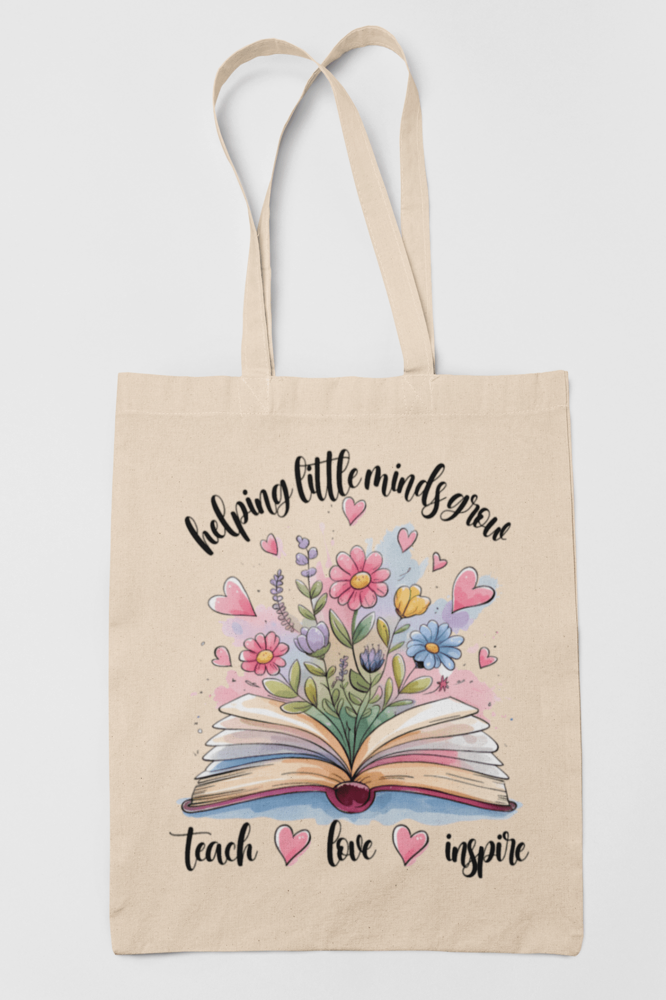 The Mirabilia Boutique "Helping Little Minds Grow Tote Bag" is a beige teacher canvas gift bag featuring an open book with colorful flowers, inspiring words, and pink hearts—perfect for teacher appreciation.