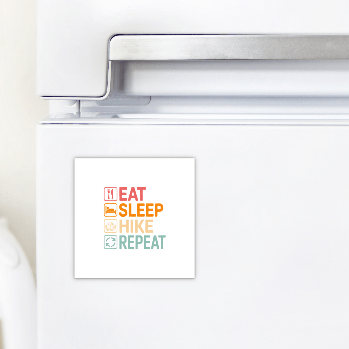 A white fridge with the Mirabilia Boutique "Eat Sleep Hike Repeat Magnet"—each word has a colorful icon. Perfect hiking gift or decor for outdoor lovers.