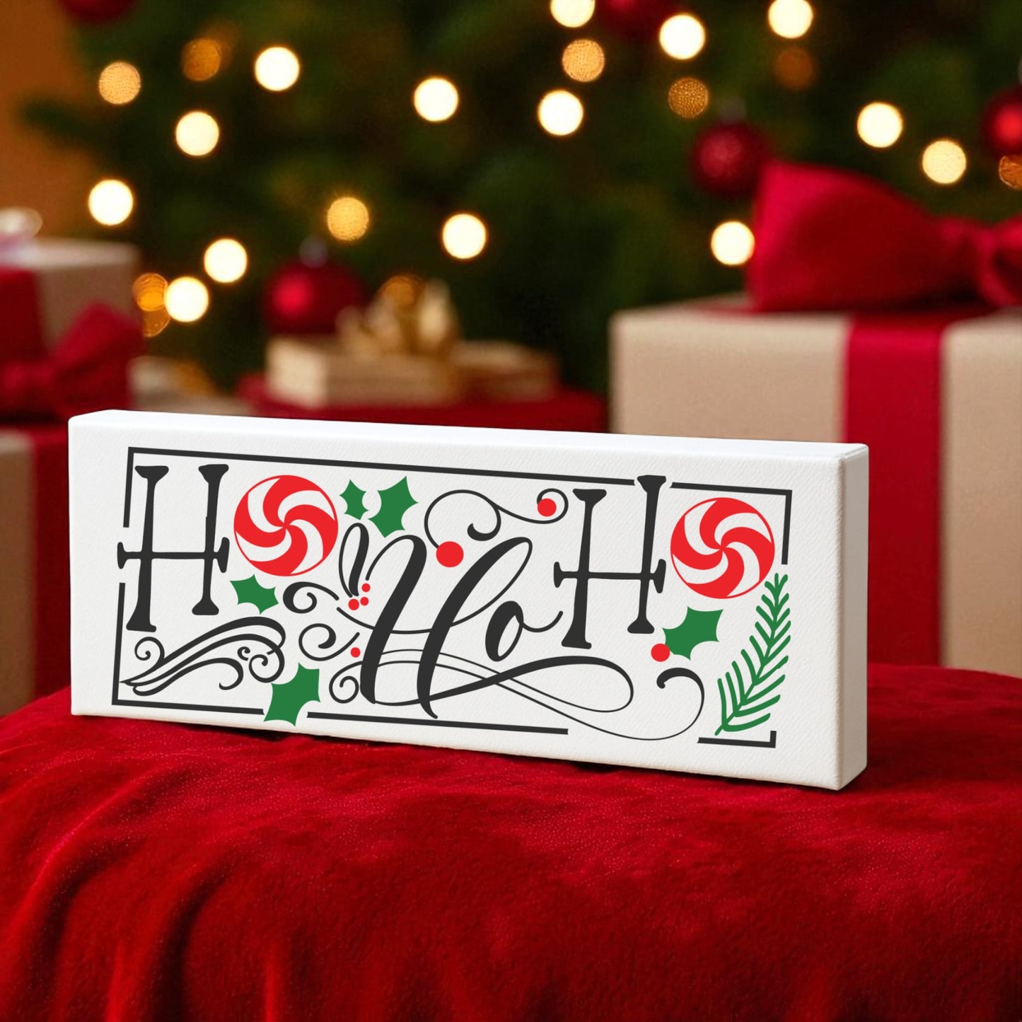 The Mirabilia Boutique Ho Ho Ho Shelf Sitter | Christmas Sign features "Ho Ho Ho!" in black script with candy canes and holly, set on a red cloth—a festive holiday decor piece perfect for your Christmas setup.