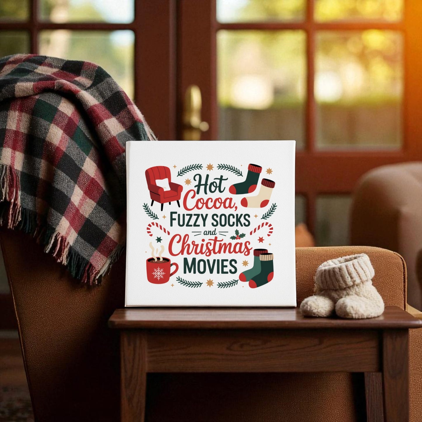 A Christmas gift idea: Mirabilia Boutique's “Hot Cocoa, Fuzzy Socks, Christmas Movies” 8x8 canvas pairs perfectly with a plaid blanket and knit baby booties for cozy holiday vibes.