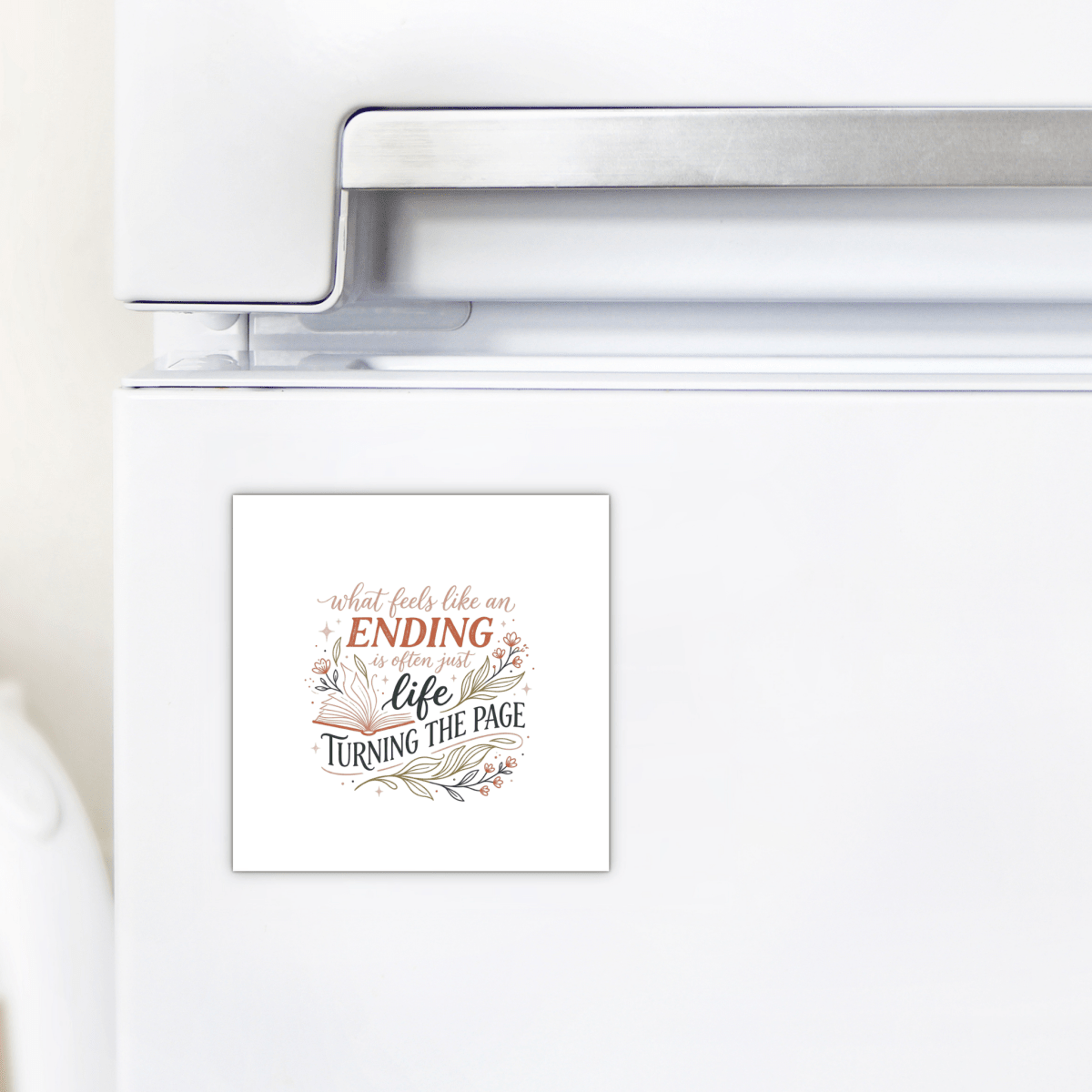 The Mirabilia Boutique Life Turning the Page Inspirational Magnet, featuring the quote "What feels like an ending is often just life turning the page," decorates a white refrigerator—a thoughtful literary gift for book lovers.