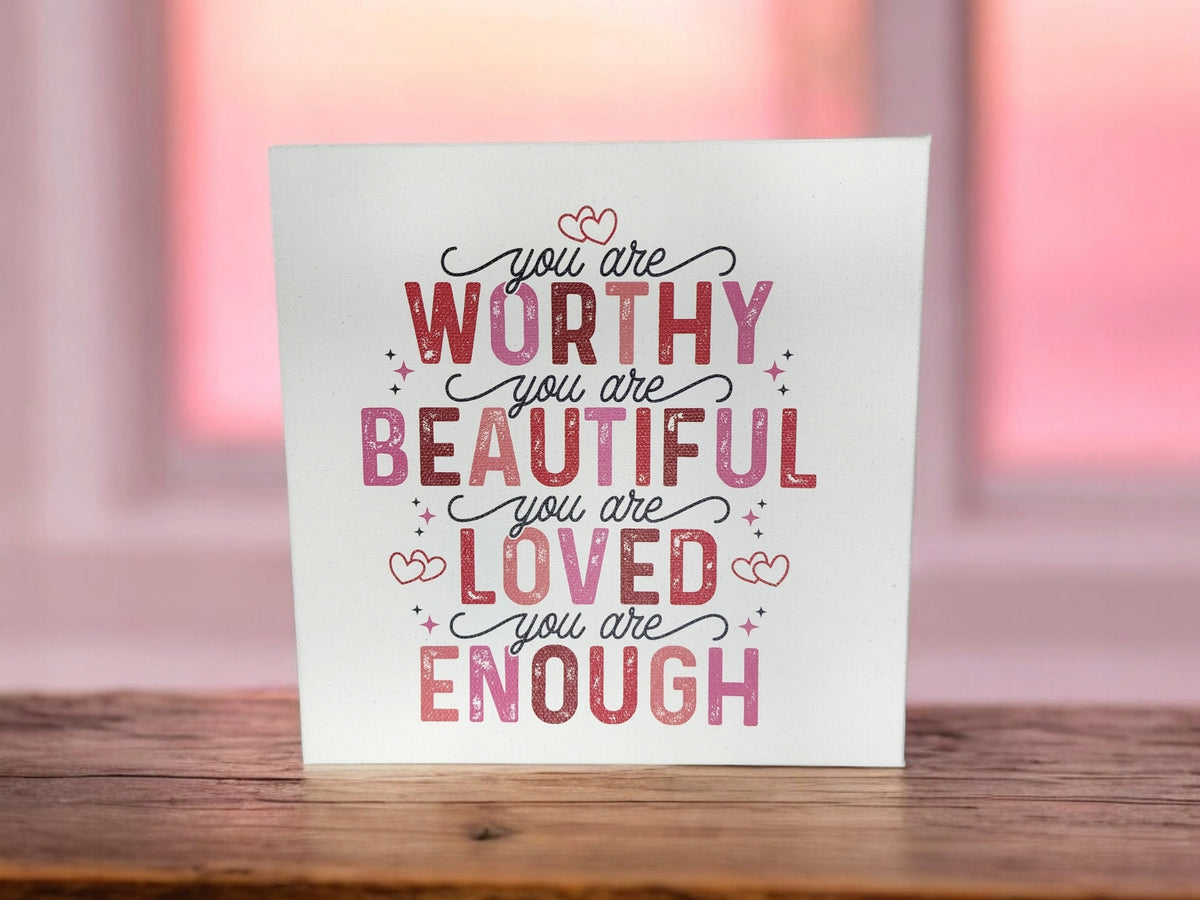 The You Are Worthy Affirmation Sign by Mirabilia Boutique is an 8x8 canvas wall art featuring "You are worthy, you are beautiful, you are loved, you are enough" in pink and red—perfect inspirational decor or a positive gift for women or teens.
