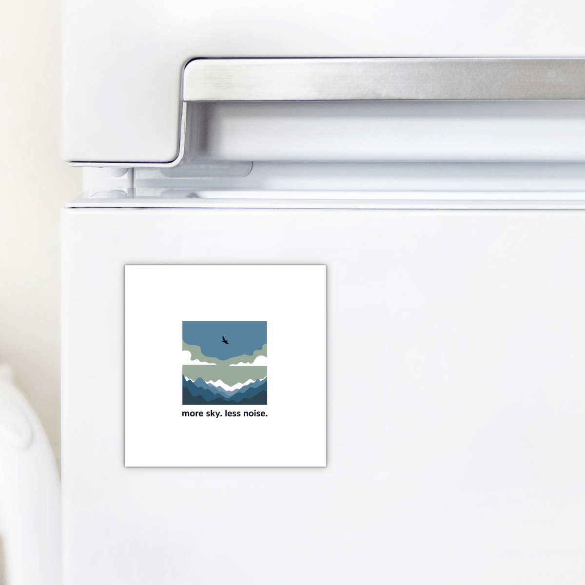 The Mirabilia Boutique More Sky Less Noise Nature Magnet features a minimalist mountain, cloud, and bird design with the words “more sky. less noise.”—a perfect outdoor gift or modern decor accent for your refrigerator.