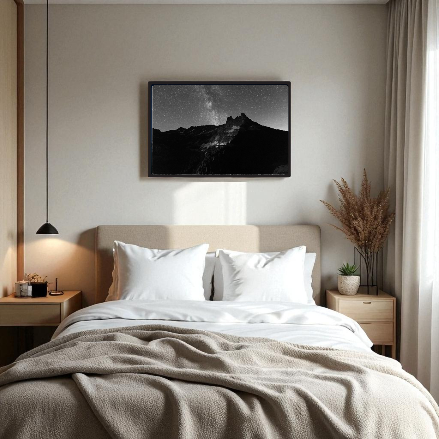 A cozy bedroom features a neatly made bed with two white pillows, bedside tables with lamps, and the Mirabilia Boutique “Liberty Bell Black & White Fine Art Print | Framed Art Print” displayed above the bed; a vase of dried plants rests on the right table.