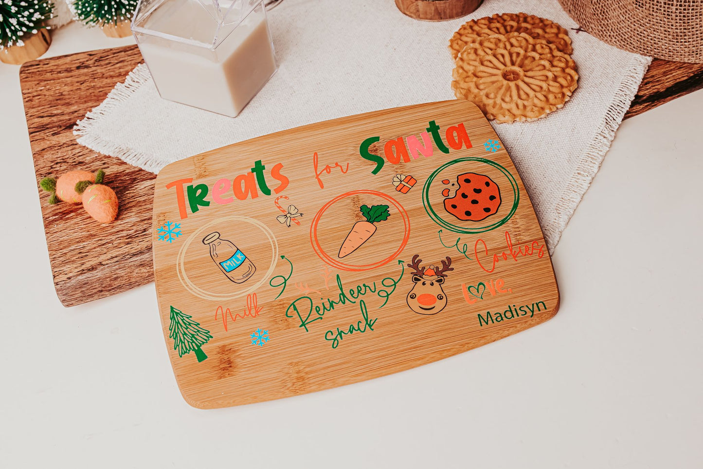 The Personalized Santa Treat Tray by Mirabilia Boutique is a custom bamboo Christmas Eve board labeled "Treats for Santa," featuring spots for milk, cookies, and a reindeer snack—perfect for leaving treats on Christmas Eve.