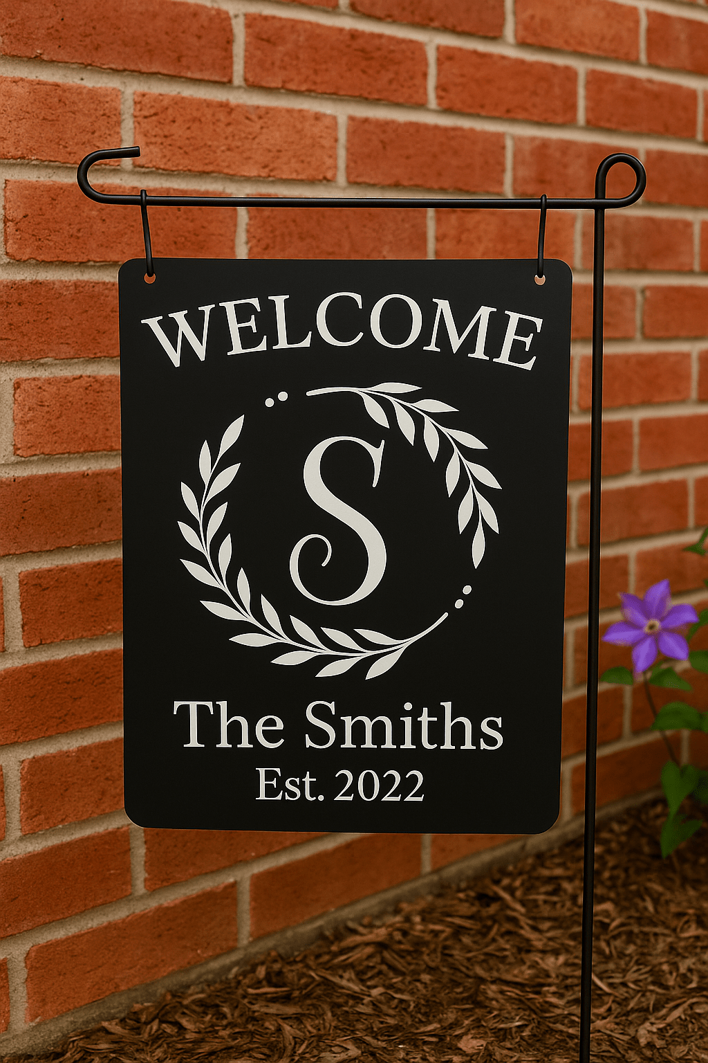 The Mirabilia Boutique Personalized Welcome Garden Sign features a custom family name and "WELCOME" design, hanging on a metal stand—perfect garden decor or housewarming gift from the Custom Family Yard Decor collection.