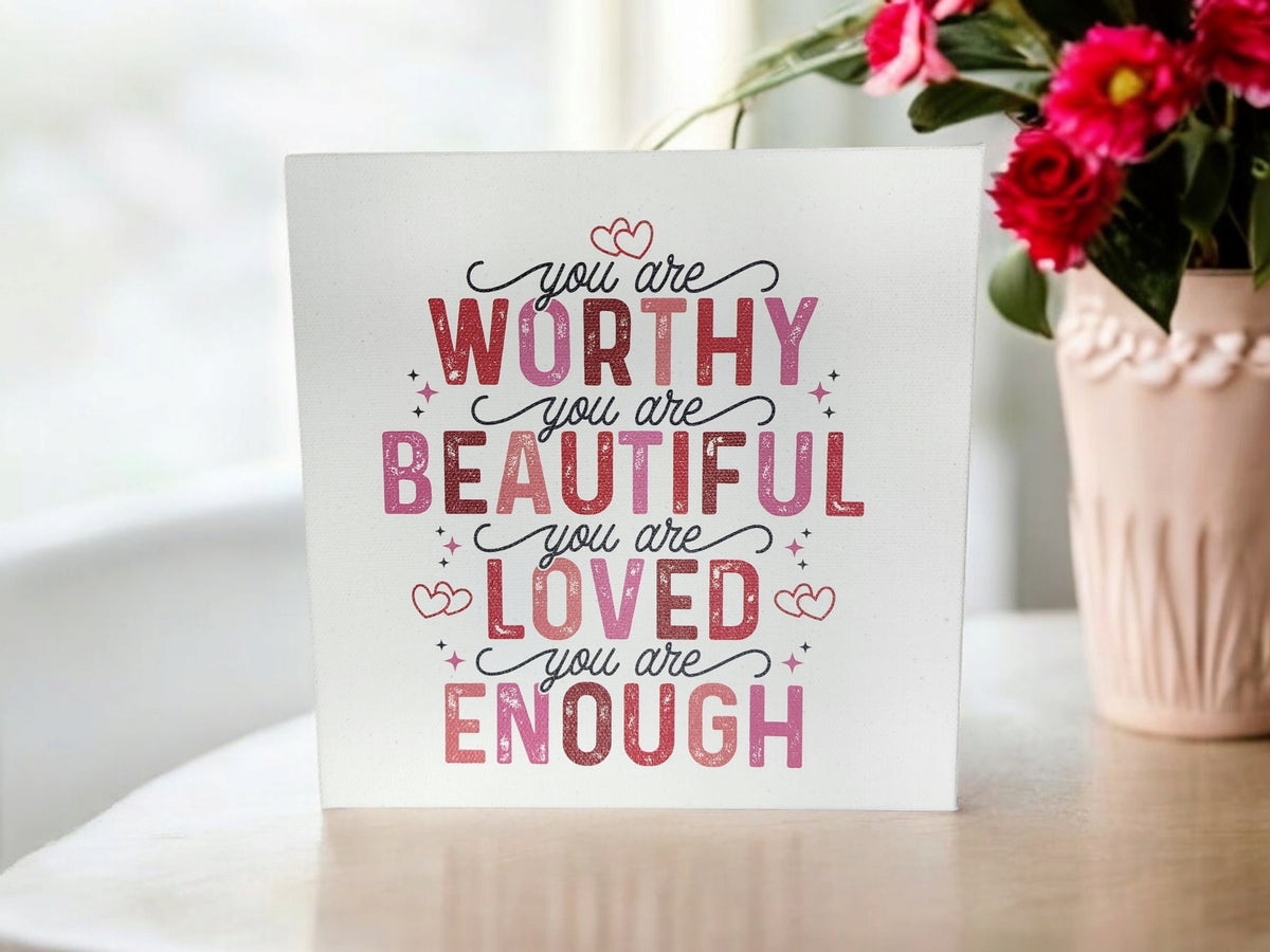 The Mirabilia Boutique "You Are Worthy Affirmation Sign"—an 8x8 inspirational canvas wall art for women or teens—features pink and purple text: “You are worthy, you are beautiful, you are loved, you are enough.”.