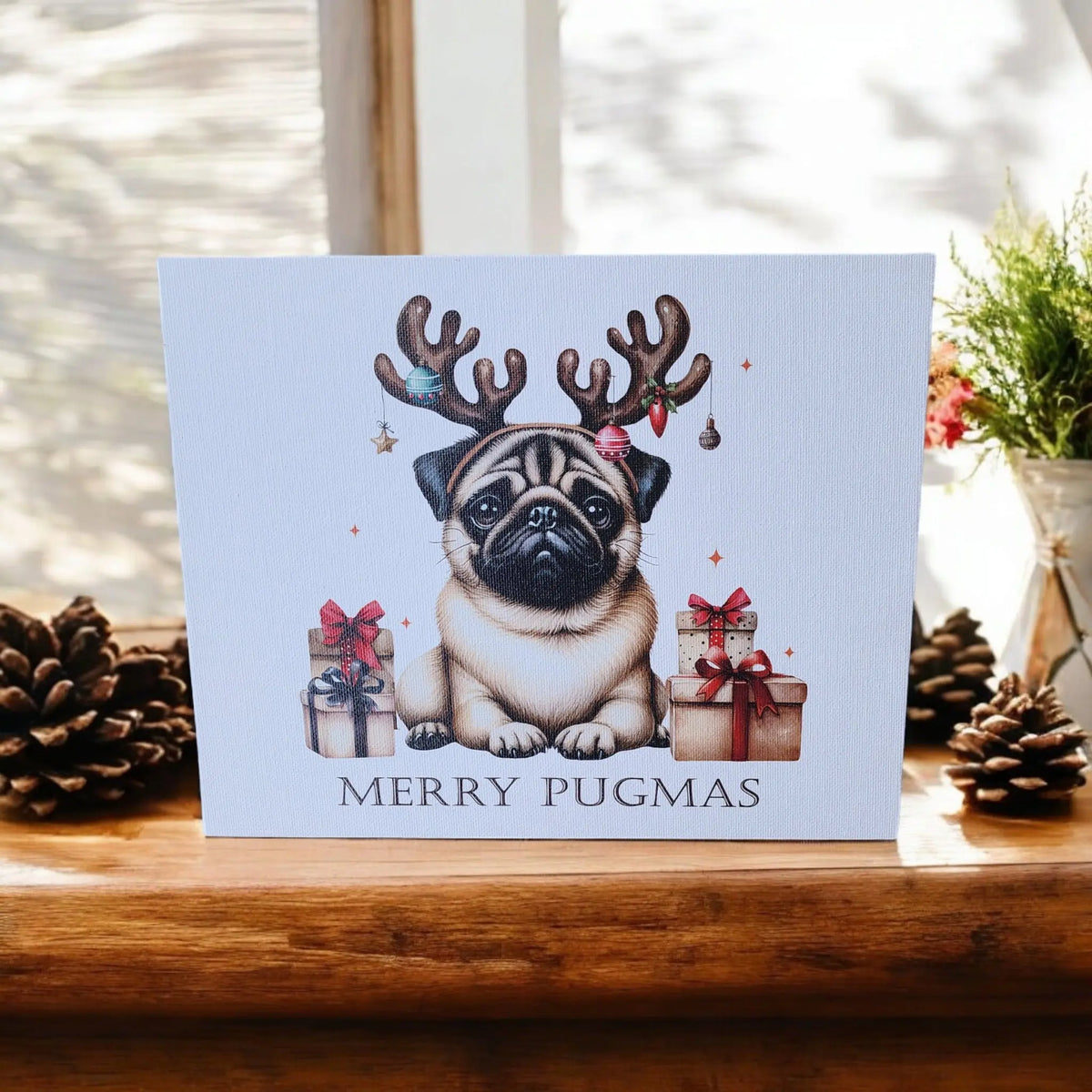 The Merry Pugmas Canvas Wall Art by Mirabilia Boutique features a pug with reindeer antlers among Christmas gifts and décor, UV printed in 8x10—perfect funny holiday gift for dog lovers. Sunlight and festive accents add charm.