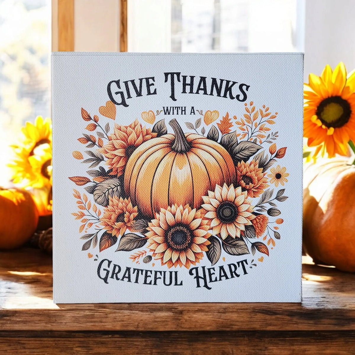 The Mirabilia Boutique "Give Thanks With a Grateful Heart" 8x8 wood sign features pumpkins and sunflowers, perfect as rustic Thanksgiving wall décor and fall accents for your home.