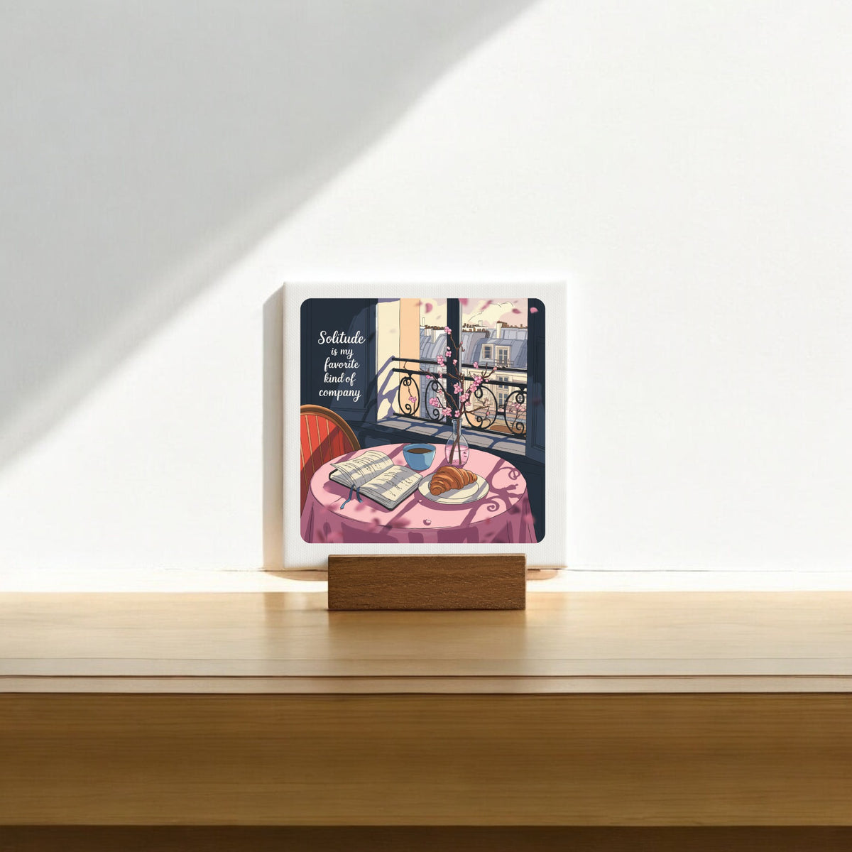 The Solitude Mini Sign – Parisian Morning Still Life by Mirabilia Boutique features a cozy table scene and the quote, "Solitude is a fine, lovely, beautiful company"—a thoughtful gift for introverts.