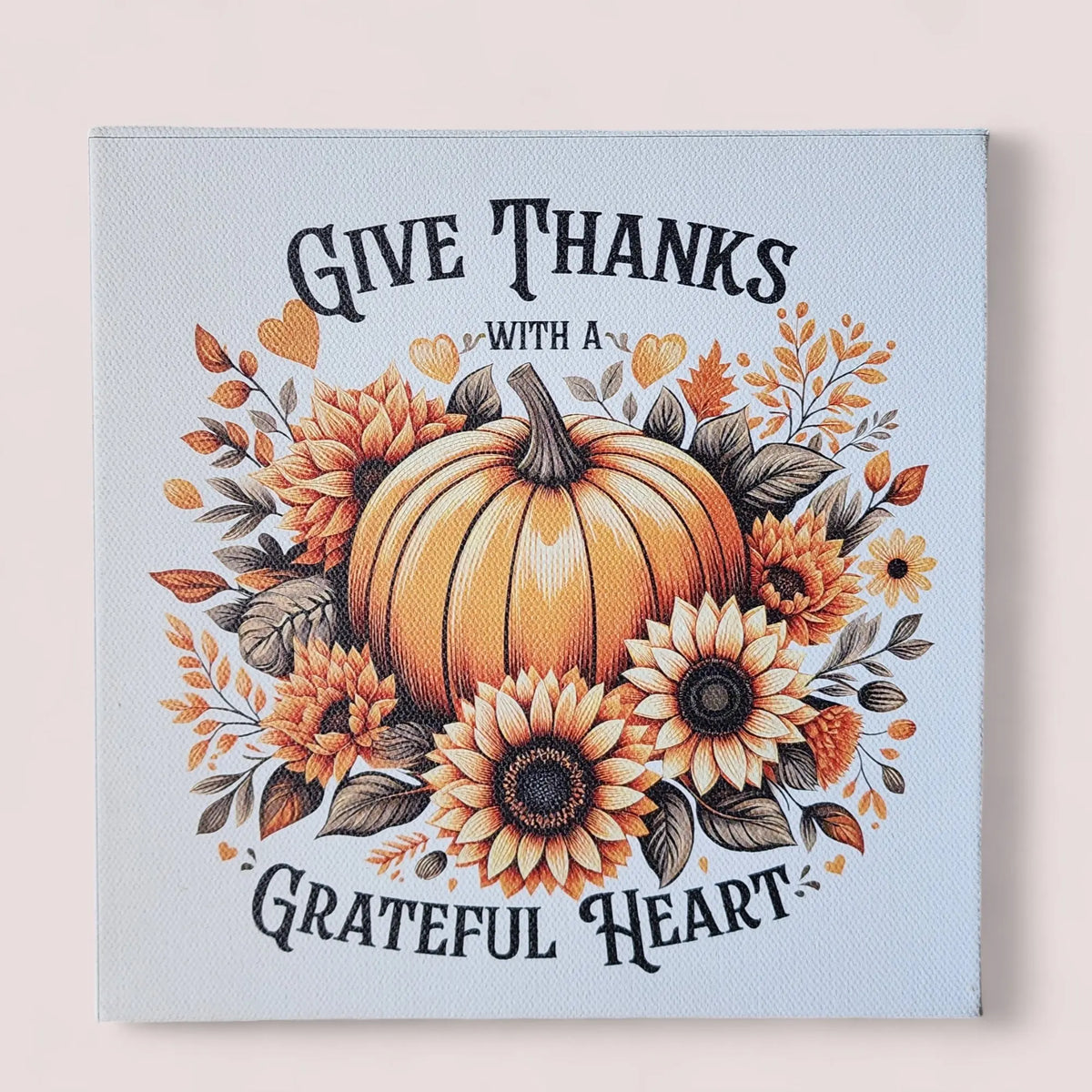 The Mirabilia Boutique "Give Thanks With a Grateful Heart" 8x8 wood sign features pumpkins and sunflowers for festive Thanksgiving décor—a charming fall wall art accent printed on cradled wood.