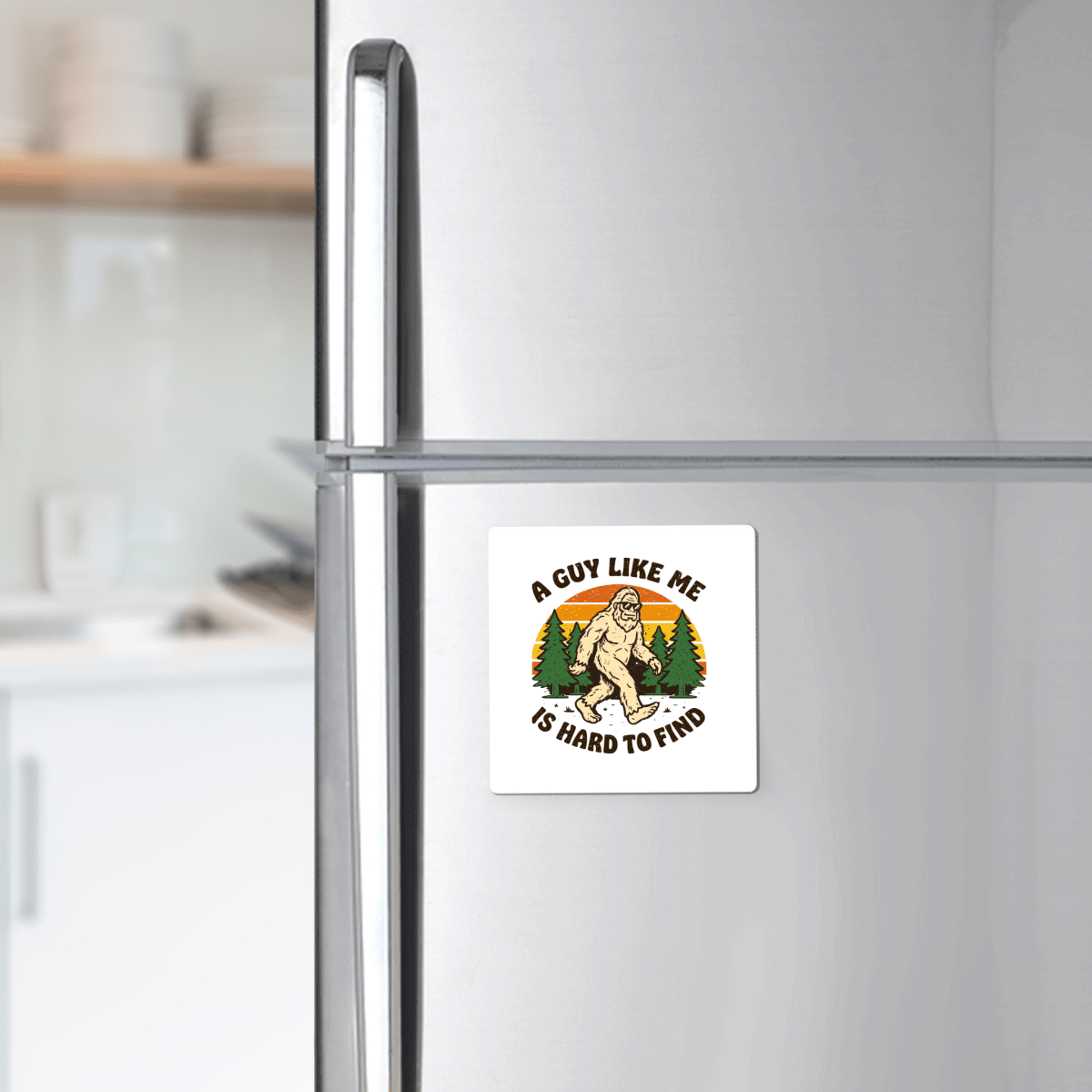 The Funny Bigfoot Magnet by Mirabilia Boutique features “A Guy Like Me Is Hard to Find” and a quirky Sasquatch forest design—perfect for adding unique charm to your fridge decor.
