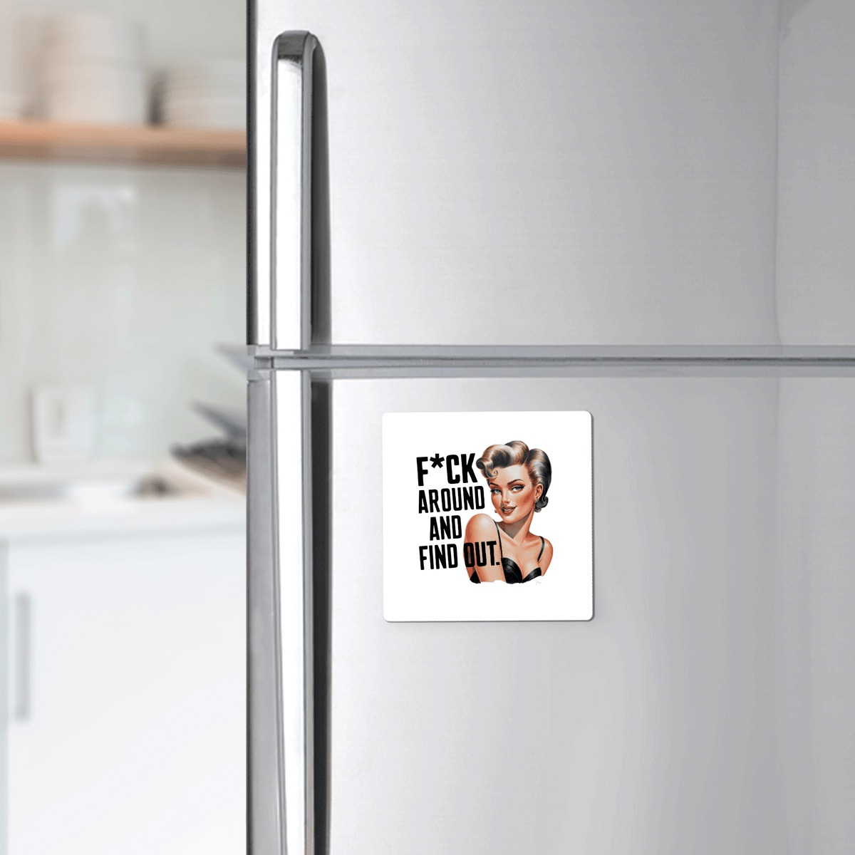 A Mirabilia Boutique “F*ck Around and Find Out” 3x3 retro magnet featuring a smiling woman and bold text, perfect as a sassy gift for friends, coworkers, or office desks. Kitchen background is blurred.
