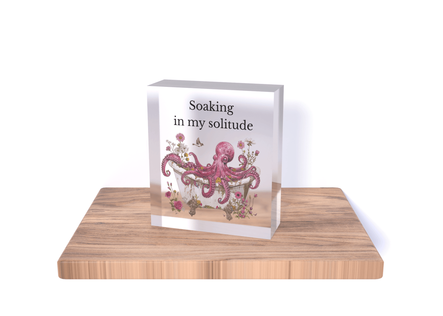 The Soaking in My Solitude Art Block by Mirabilia Boutique features a pink octopus with flowers and butterflies on an acrylic block set in wood—a whimsical decor piece and unique solitude gift for octopus lovers.