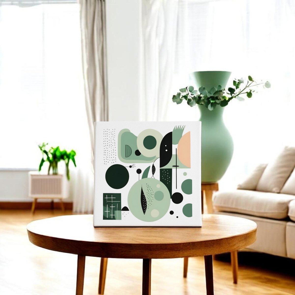 A modern living room features the Spring Geometry Mid Century Modern Canvas by Mirabilia Boutique, with its green and black geometric design above a round wooden table; a large green vase with eucalyptus adds a touch of spring.