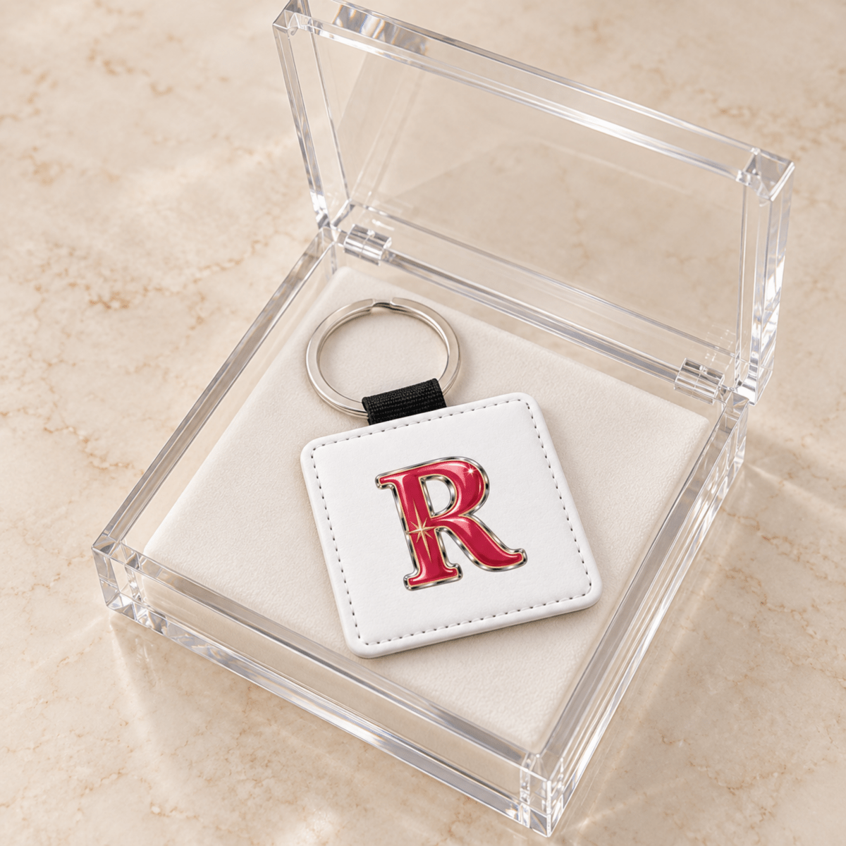 Stardust Enamel Personalized Monogram Keychain | Chrome & Starlight: a square white stardust enamel keychain featuring a red, chrome-outlined letter R in a clear acrylic gift box.