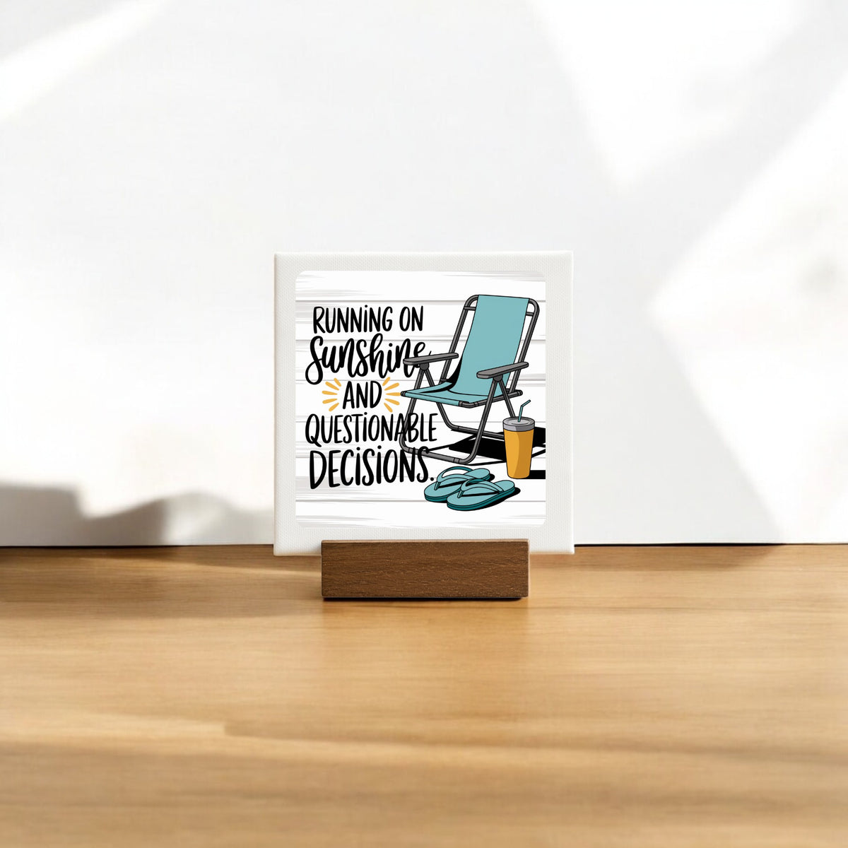 The Running on Sunshine Mini Canvas (4x4) by Mirabilia Boutique features a lounge chair, sunglasses, and drink with the phrase "Running on sunshine and questionable decisions." A fun summer sign perfect for poolside decor.