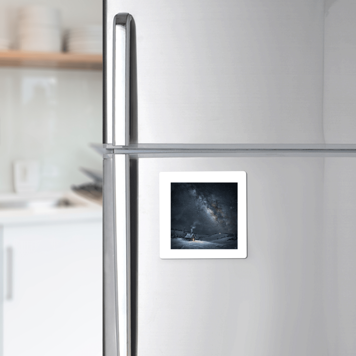 A “The Night Is Listening Milky Way Magnet” from Mirabilia Boutique, showcasing celestial art, is attached to a silver refrigerator in a modern kitchen.