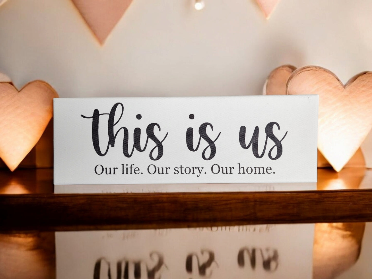 The Mirabilia Boutique "Our Story Shelf Sitter Sign" (4x12 canvas) features the quote, "This is us. Our life. Our story. Our home."—a heartfelt, handmade decor piece perfect for housewarmings or couple gifts.