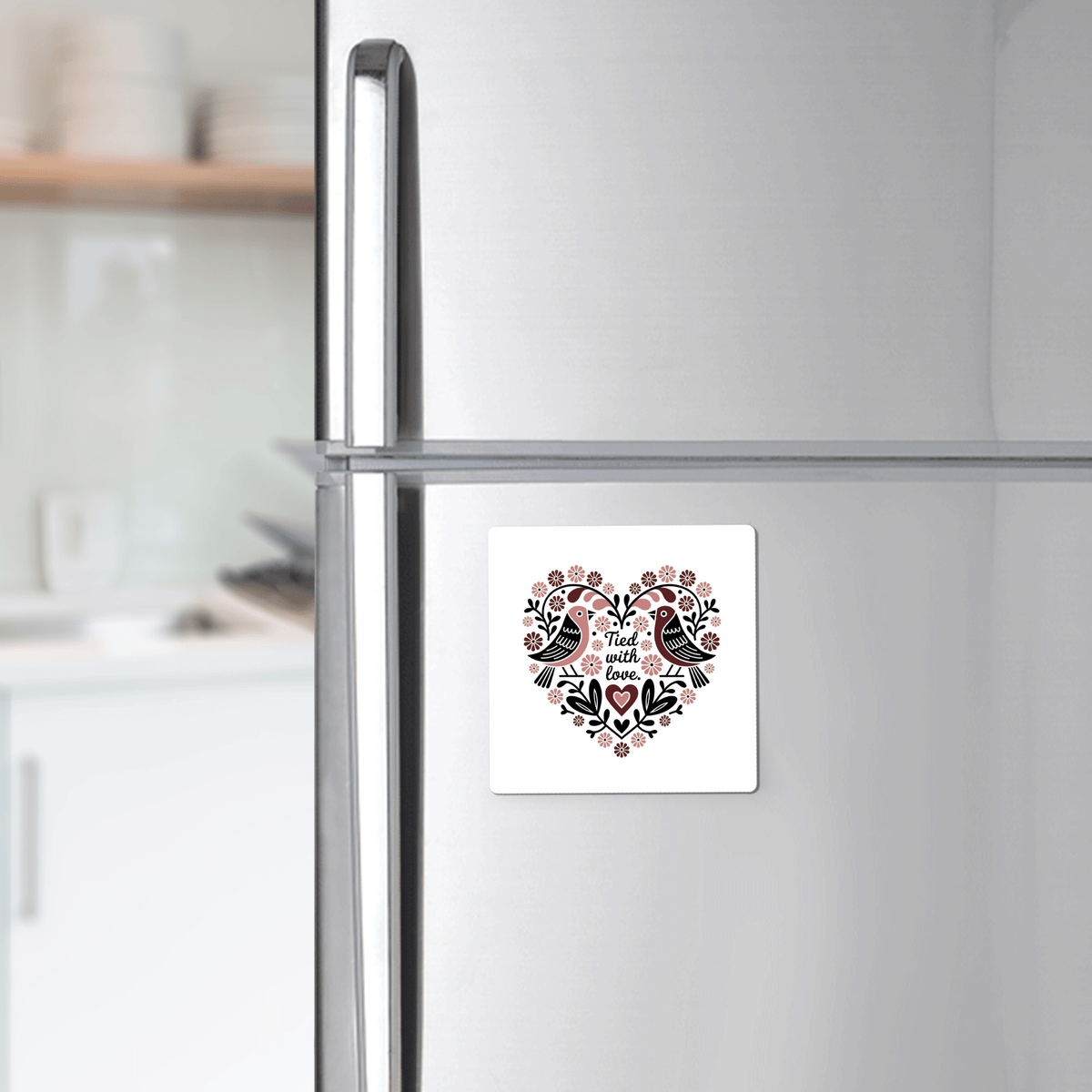 The Tied With Love Birds Magnet by Mirabilia Boutique features a heart-shaped floral design with two birds and "And then there was love" text—perfect as a charming love magnet or unique wedding favor.