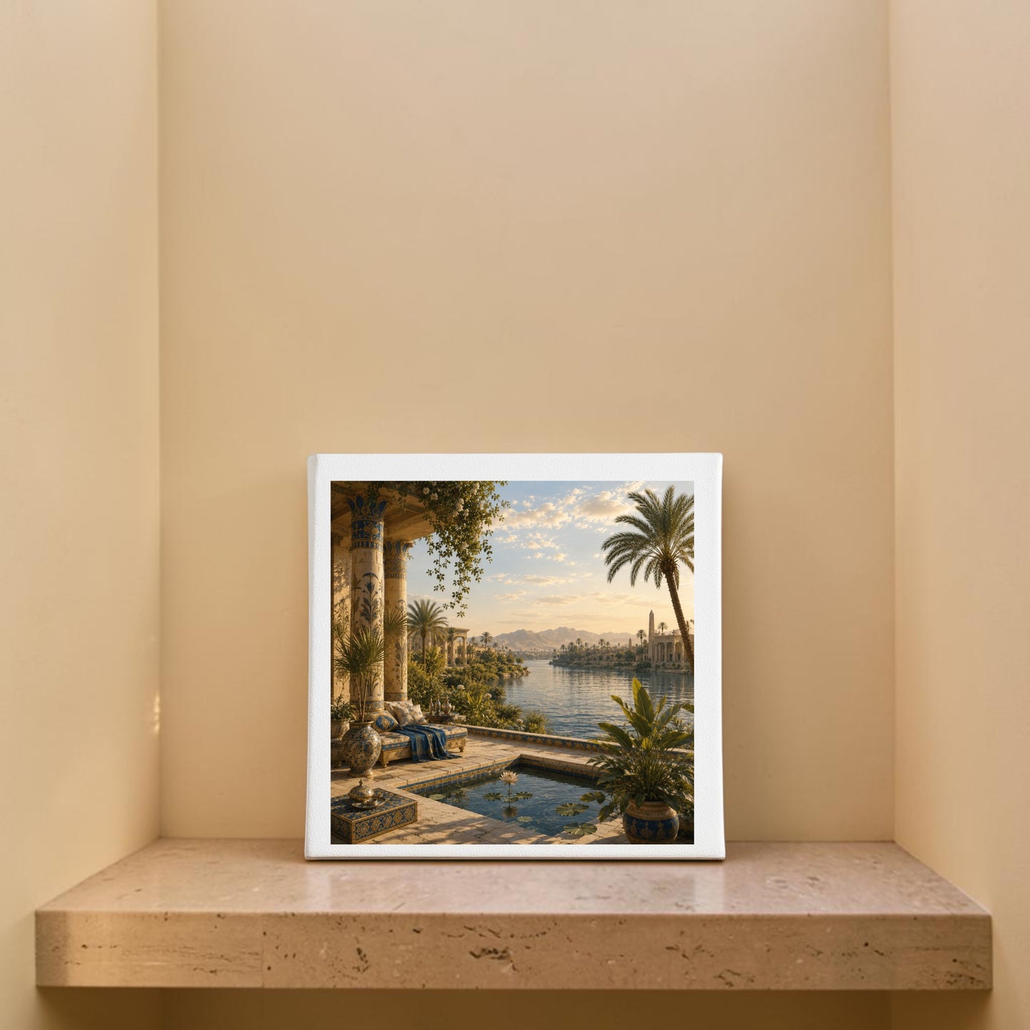 ‘View of the Nile | Egyptian Canvas Wall Art’ by Mirabilia Boutique, featuring a framed tropical riverside scene with palm trees and architectural columns evocative of Nile river artwork, is displayed on a beige marble shelf in a corner with light tan walls.
