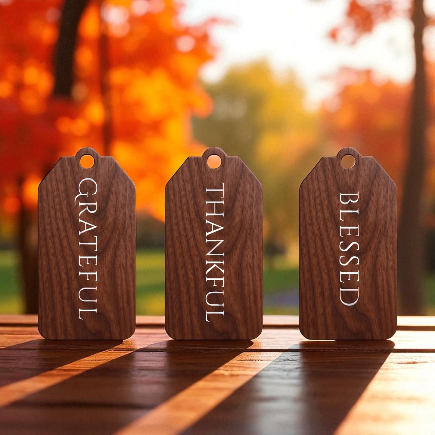The Autumn Blessings Tags by Mirabilia Boutique feature three walnut wood décor tags engraved with "GRATEFUL," "THANKFUL," and "BLESSED"—perfect Thanksgiving accents for your table.