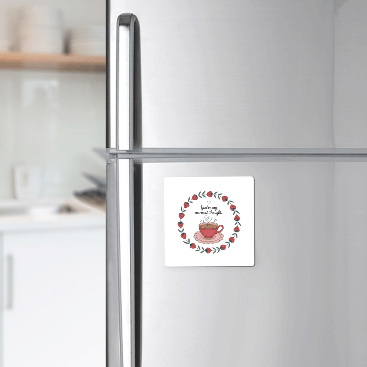 The Warmest Thought Tea Cup Magnet by Mirabilia Boutique, featuring a red teacup and wreath with “You are my cup of tea,” adorns your fridge—a charming best friend gift and stylish touch for any modern kitchen.